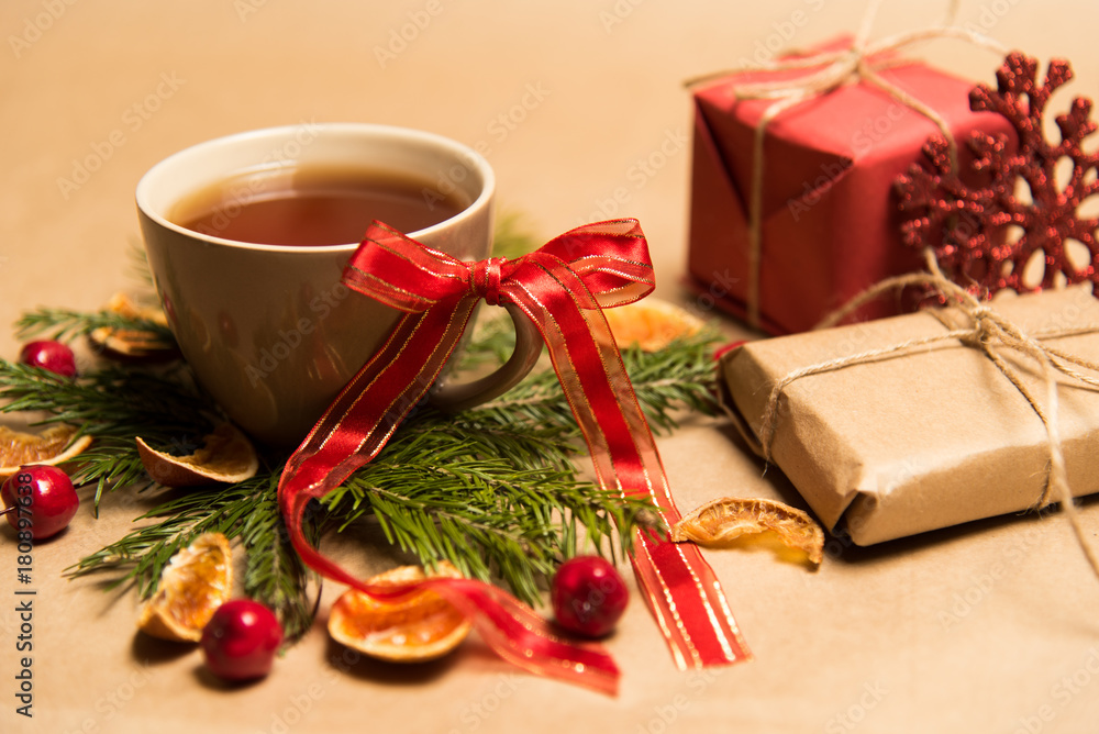 Cup of black tea, Christmas toys, gifts and decorations on craft background