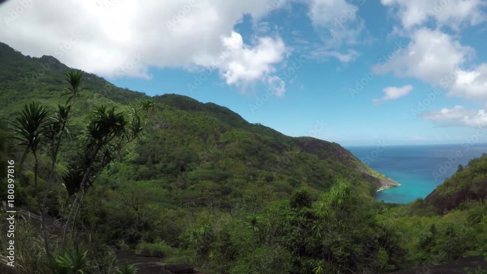 Go Pro view from Silhouette island, Seychelles onto Anse Mondon beach below the giant granitic rock boulders (granite island) from above the forest/jungle. POV. Go Pro view from Silhouette island, Seychelles onto Anse Mondon beach below the giant granitic rock boulders (granite island) from above the forest/jungle. POV.