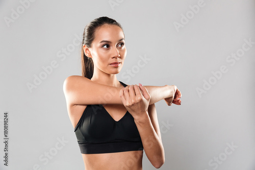 Concentrated young sports woman make stretching exercises