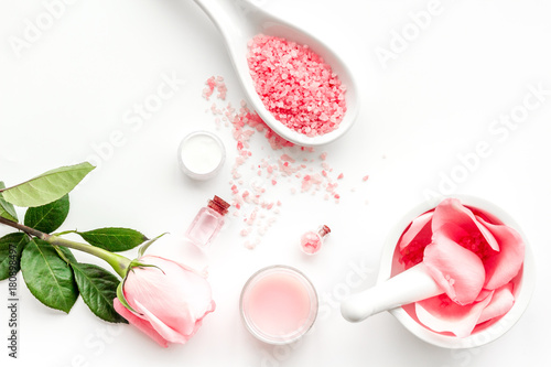 Make cosmetics with rose oil. Mortar with rose petals and pestle on grey stone background top view copyspace