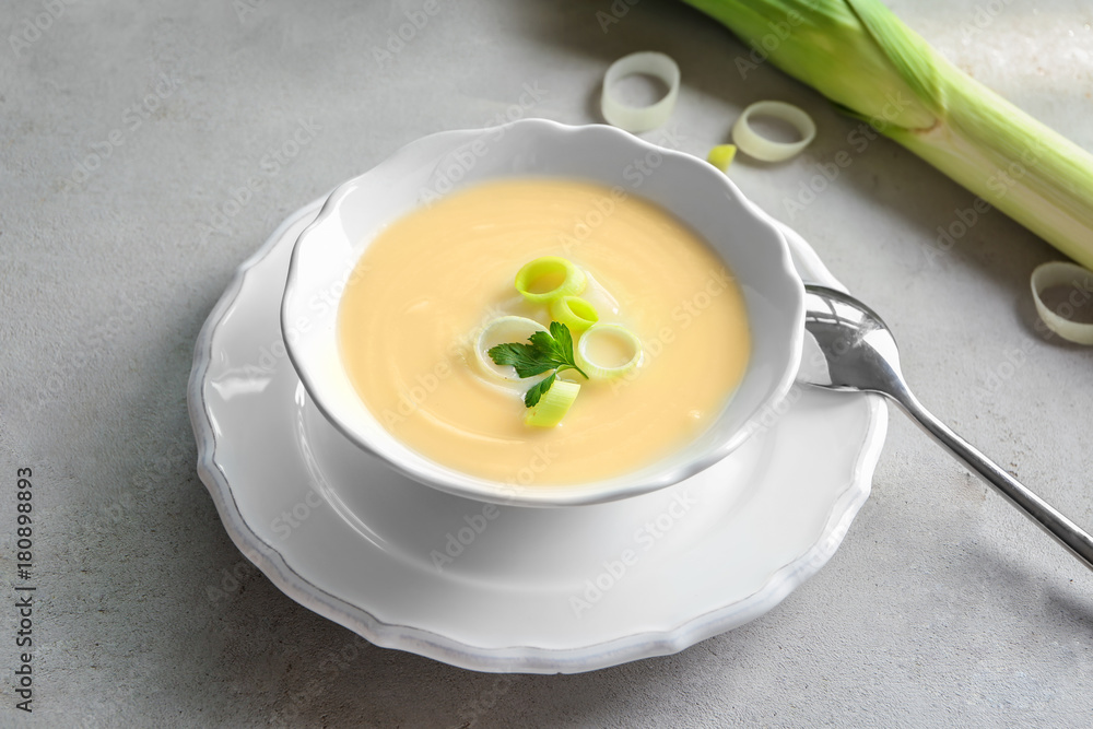 Bowl of yummy potato soup with leek on table Bowl of yummy potato soup with leek on table