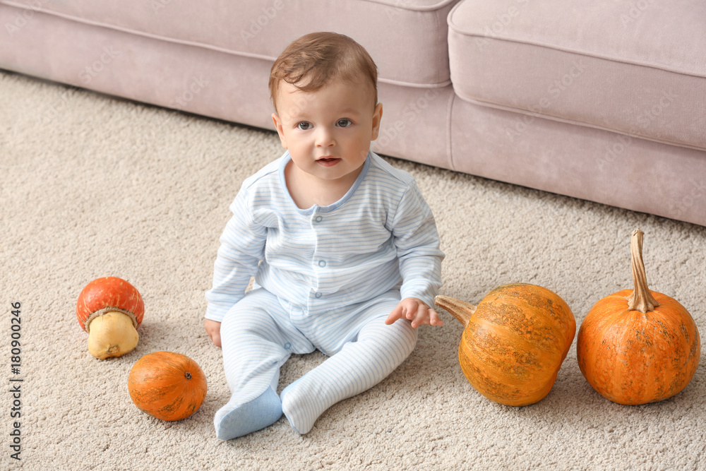 Fototapeta premium Adorable baby with pumpkins indoors
