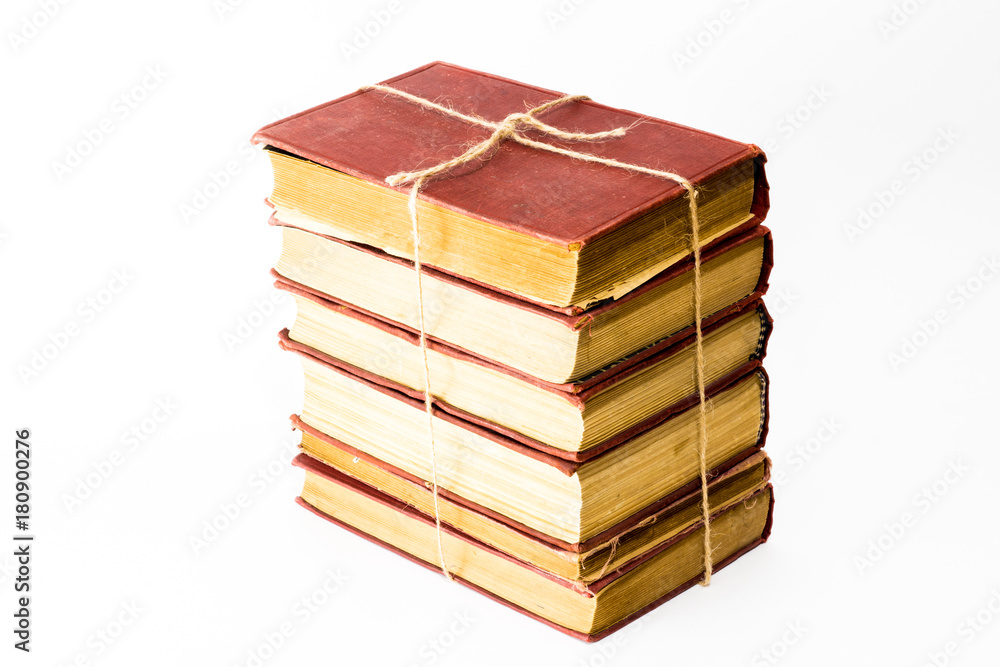 The pile of books on the white background linked with a cord. The books are isolated on white and a clipping path is provided for easy extraction. Association with resettlement The pile of books on the white background linked with a cord. The books are isolated on white and a clipping path is provided for easy extraction. Association with resettlement
