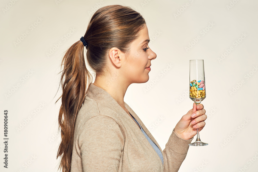 Young woman holding glass with vitamins pills Young woman holding glass with vitamins pills