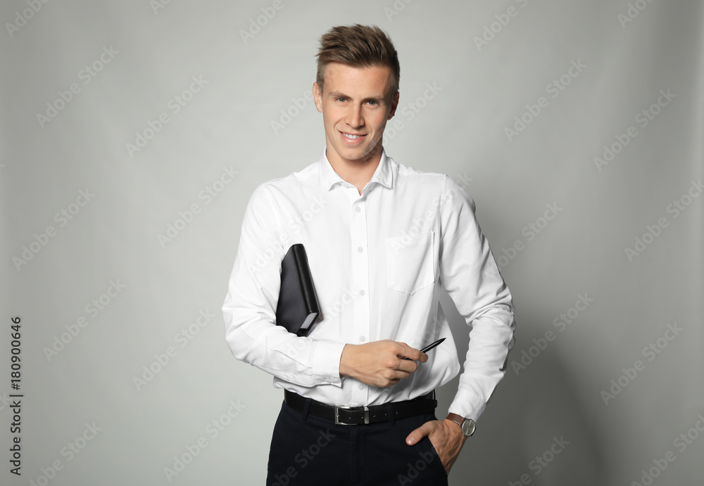 Attractive young manager with notebook on light background Attractive young manager with notebook on light background