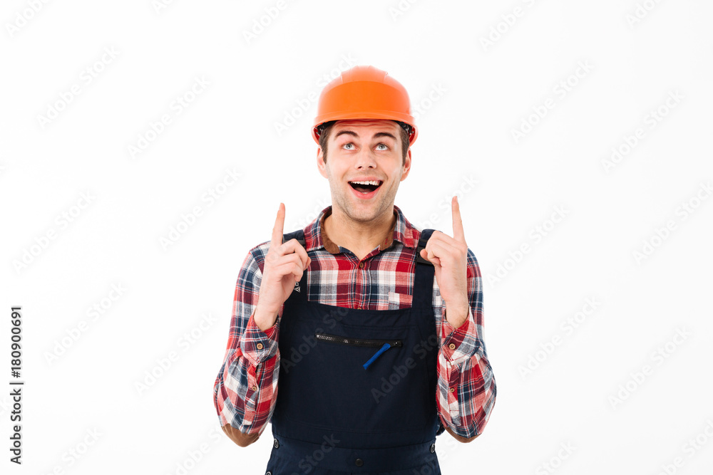 Portrait of a amused young male builder pointing two fingers
