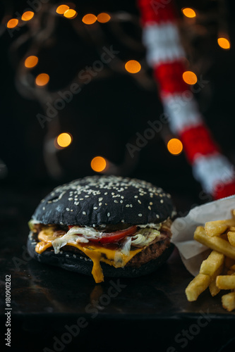 Black burger on table. Christmas concept for fast food