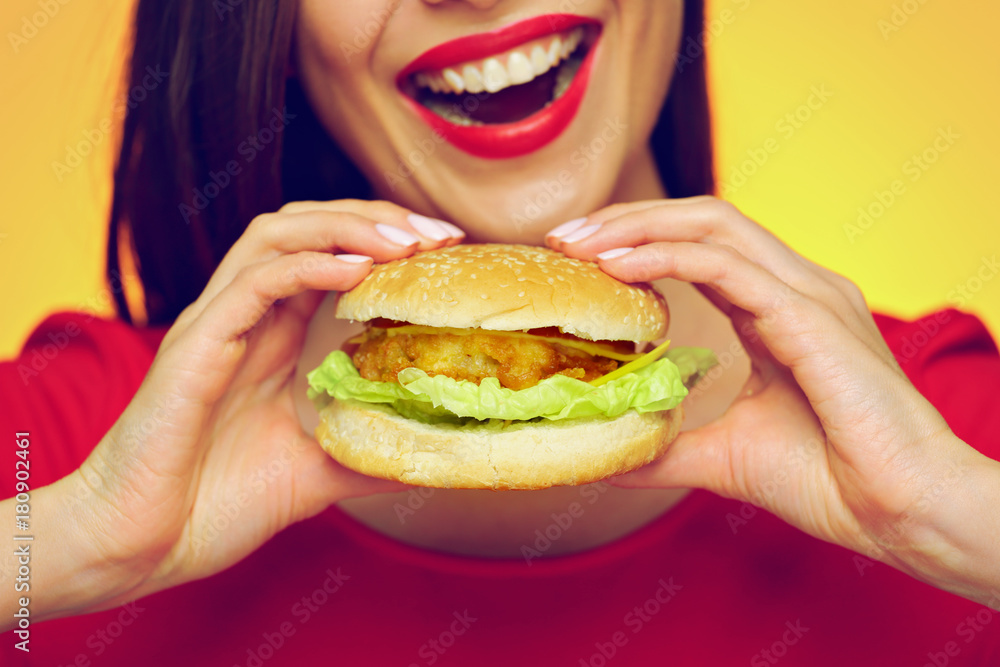 Close up face portrait of smiling woman holding big burger.