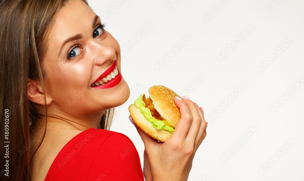 Smiling woman wearing red dress holding burger.
