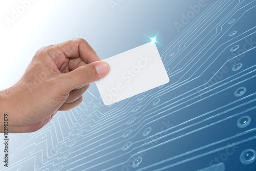 Credit card newest technology .Man hand holding white blank credit card with electronic circuit board background.