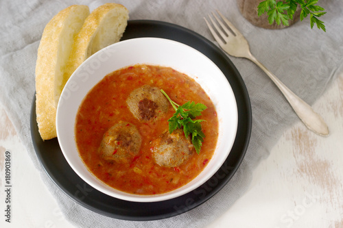 Meatballs in tomato apple sauce served with bread. Rustic style.