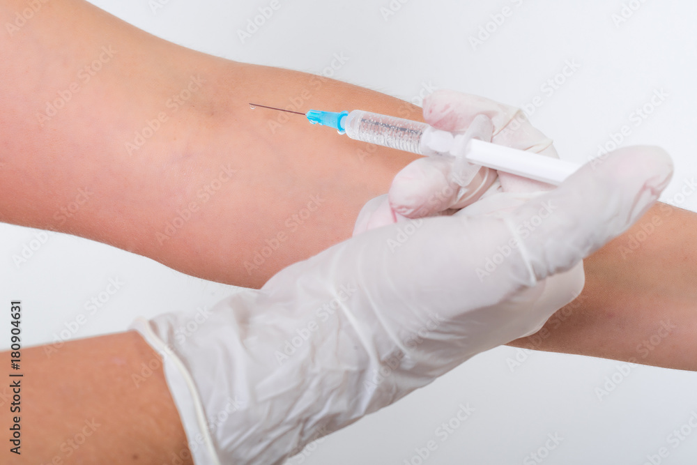 The medical worker injects into the hand in the treatment room. The medical worker injects into the hand in the treatment room.