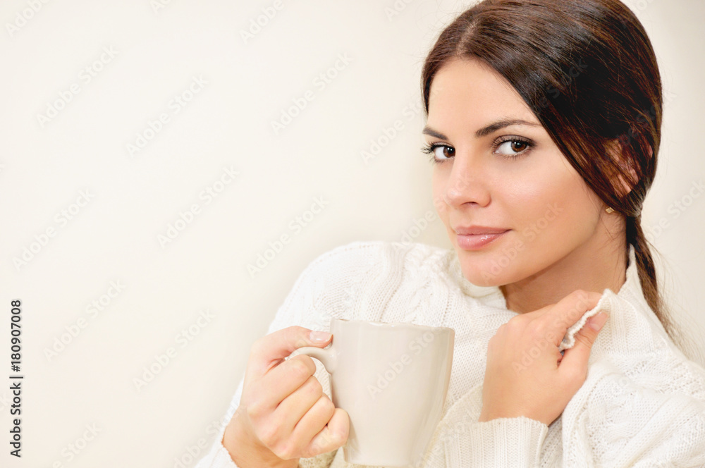 Beautiful young woman enjoying a cup of coffee while relaxing at home Beautiful young woman enjoying a cup of coffee while relaxing at home