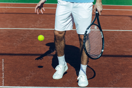 This court makes a game. Close-up part of man playing tennis on the tennis court.  © MARIIA