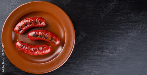 Tablou canvas Round clay dish with toasted apetit sausages