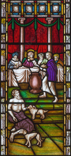 LONDON, GREAT BRITAIN - SEPTEMBER 19, 2017: The Parable of Rich man and Lazarus on the stained glass in St Mary Abbot's church on Kensington High Street.