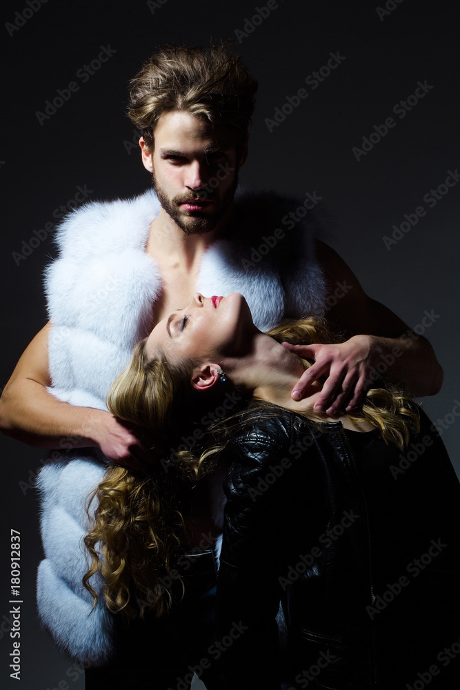 Man in fur vest hold woman on long blond hair Man in fur vest hold woman on long blond hair