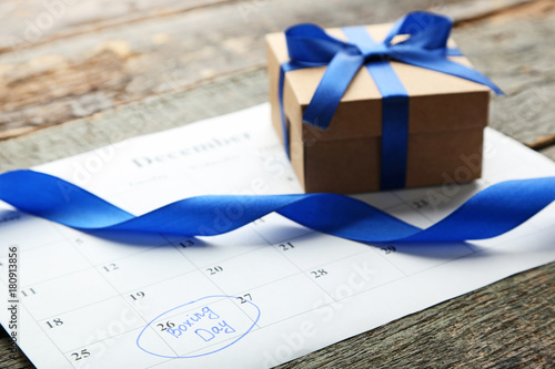 Gift box and calendar list on wooden table. Boxing day concept photo