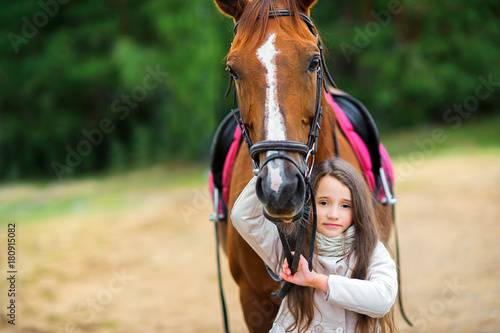 teen girl walks with her favorite horse.