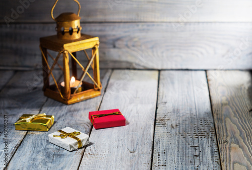 Lantern with a candle and Christmas decorations on a white wooden surface