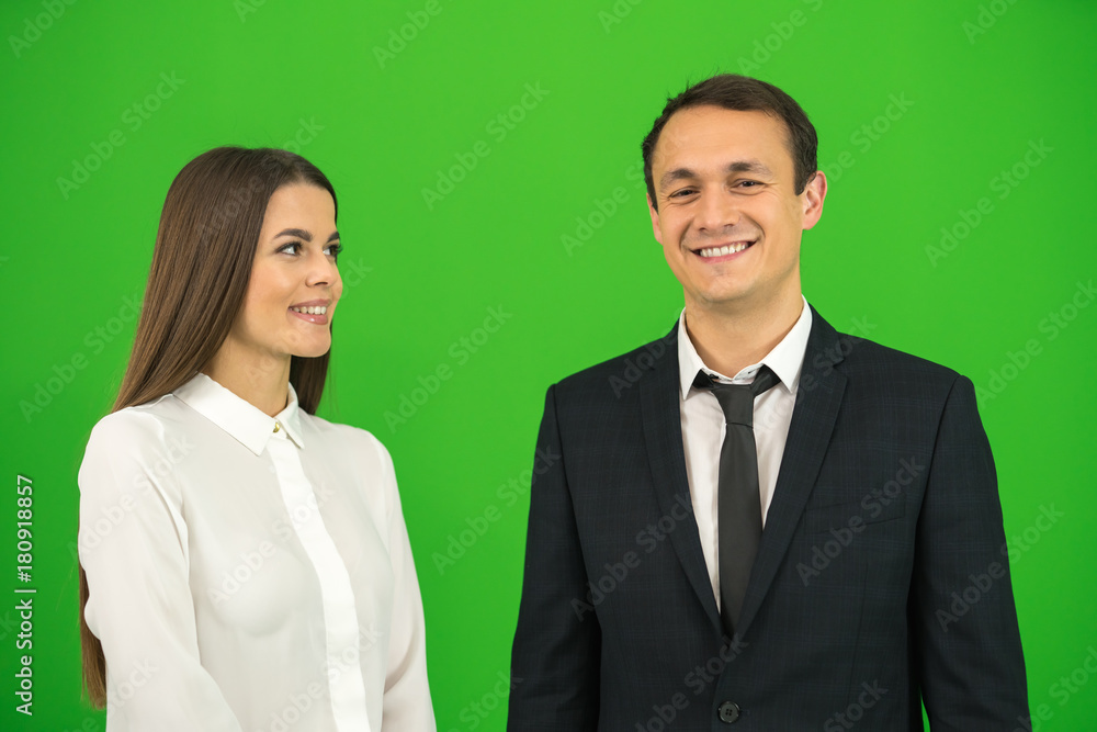 The happy businessman and businesswoman stand on the green background The happy businessman and businesswoman stand on the green background