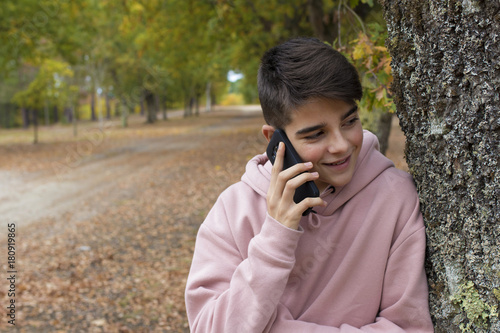 teenager talking on mobile phone outdoors in autumn