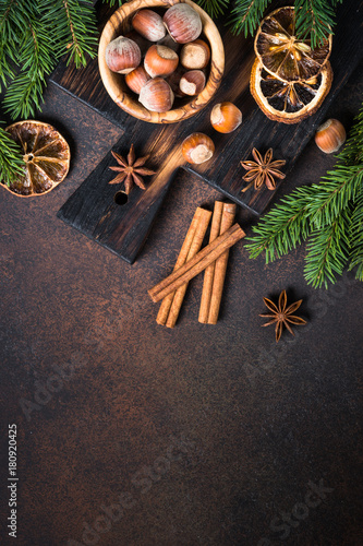 Christmas spices and nuts on rusty stone table. Christmas baking background.