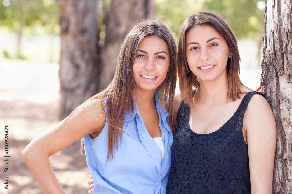 Obraz premium Two Beautiful Ethnic Twin Sisters Portrait Outdoors.