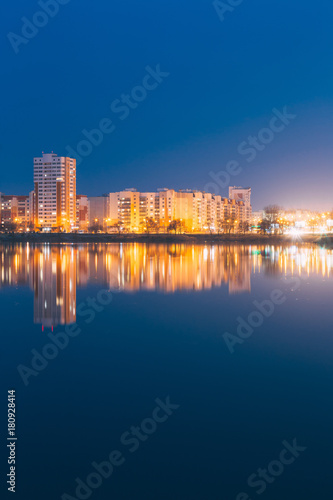 Night View Of Urban Residential Area Overlooks To City Lake Or River And Park In Evening Illumination 