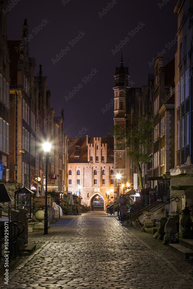 View of old buildings on the empty St. Mary's Street (ul. Mariacka) and St. Mary's Gate (Brama Mariacka) at the Main Town (Old Town) in Gdansk, Poland, in the evening.