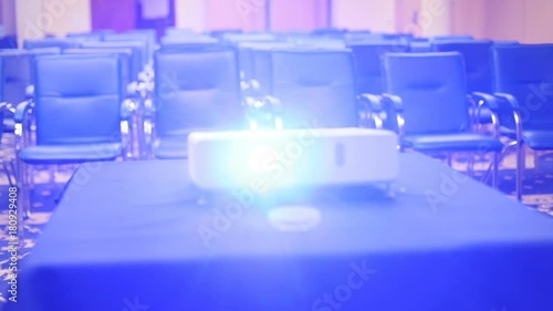 top front view projector working light table neat rows empty seats conference hall background chairs business ready meeting room formal event seminar presentation nobody inside entertainment education photo