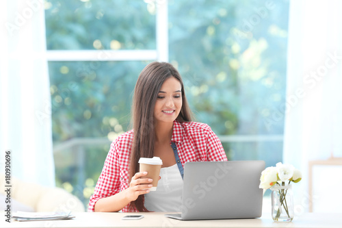 Young woman with laptop and...