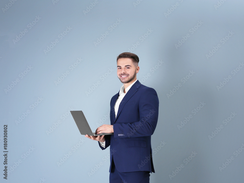 Young man with laptop against light background Young man with laptop against light background