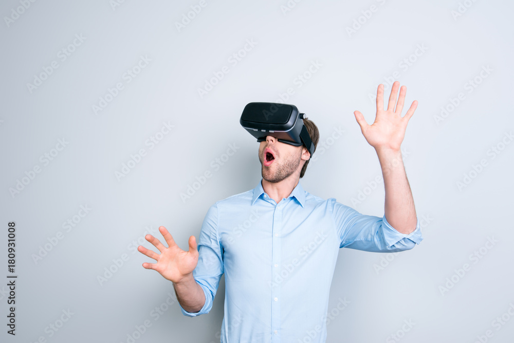 Close up of cheerful student in shirt wearing virtual reality goggles, getting experience using VR-headset of virtual reality, gesticulating, touching something with his hands Close up of cheerful student in shirt wearing virtual reality goggles, getting experience using VR-headset of virtual reality, gesticulating, touching something with his hands