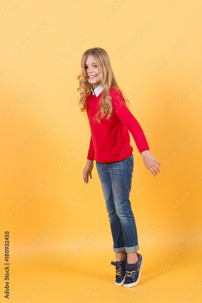 Girl in red sweater and jeans stand on tiptoe Girl in red sweater and jeans stand on tiptoe