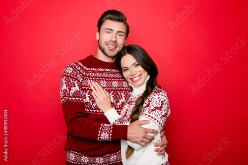 Celebrate winter feast! X mas noel. Adorable sweet caucasian couple bonding, so excited in knitted cute traditional x mas costumes with ornament, cuddle, enjoy, lady has a toothy grin