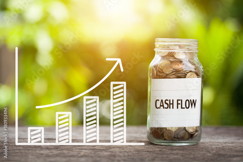 Cash Flow Word With Coin In Glass Jar and graph up. Financial Concept photo