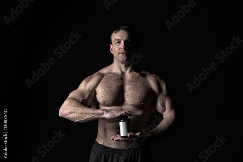 Coach sportsman hold dieting pill, vitamin.