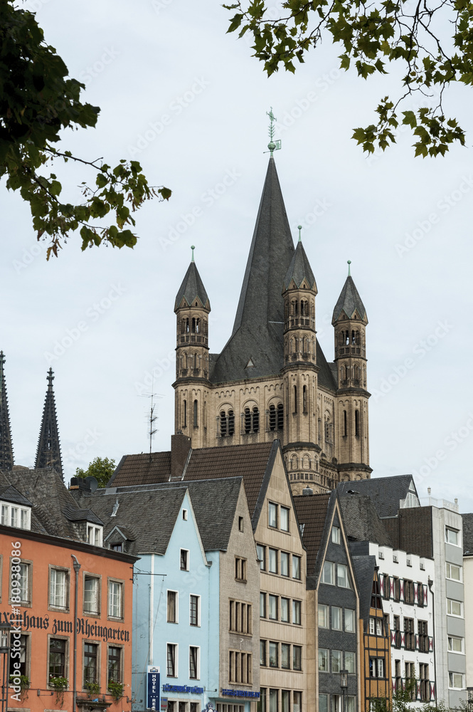COLOGNE, GERMANY - SEPTEMBER  11, 2016: Colorful houses in Bavarian style and the Romanesque Catholic church 