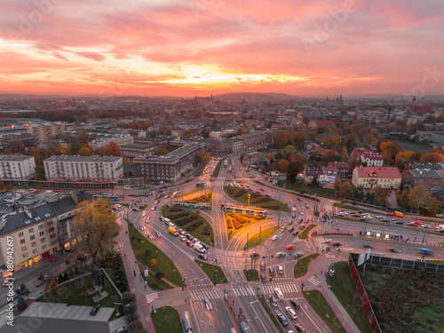 Aerial view of Krakow, Poland. Transportation, rush hour traffic, cars on highway interchange in city center. Sunset time, orange and gold light. Skyline, beautiful sky. © dendidenko