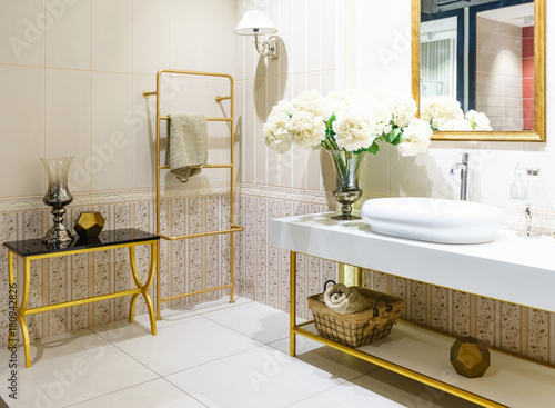 Modern spacious bathroom with bright tiles with toilet and sink. Side view