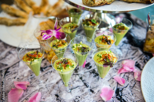 Green avocado coctail shots served on catering buffet table