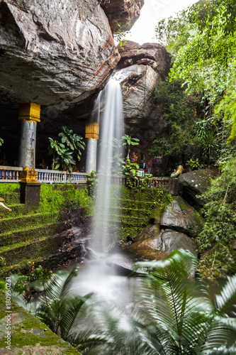 Motion blurred water and children play in  the temple under waterfall Wat Tham Heo Sin Chai waterfall. Kaeng Tana National Park, Ubonratchathani, Thailand photo