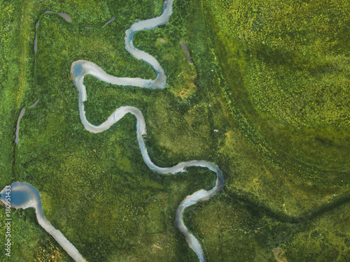 aerial landscape of winding river in green field, top view of beautiful nature texture from drone