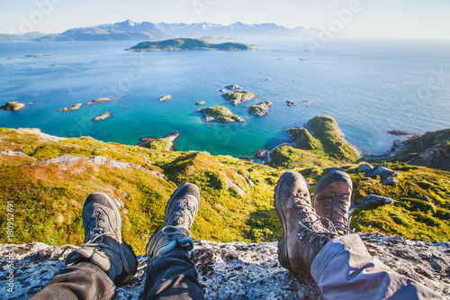 feet of people hikers relaxing on top of the mountain, travel background, hiking shoes photo