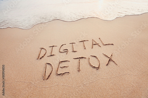 digital detox concept, words written on the sand of beach