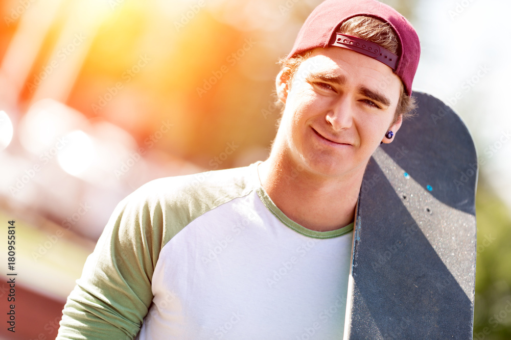 Teenage boy with skateboard standing outdoors Teenage boy with skateboard standing outdoors