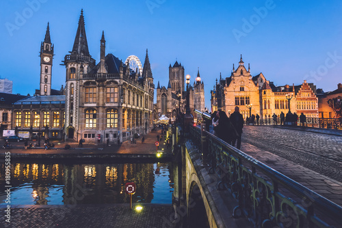 Ghent  Belgium - December 27th  2016. Saint Michael s bridge panoramic view with merchant houses on Graslei street  Saint Nicholas church and Clock Tower. Gent Old town by Christmas evening lights.