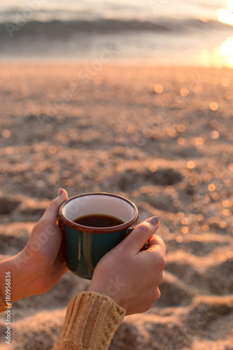 Female hands holding a mug with tea