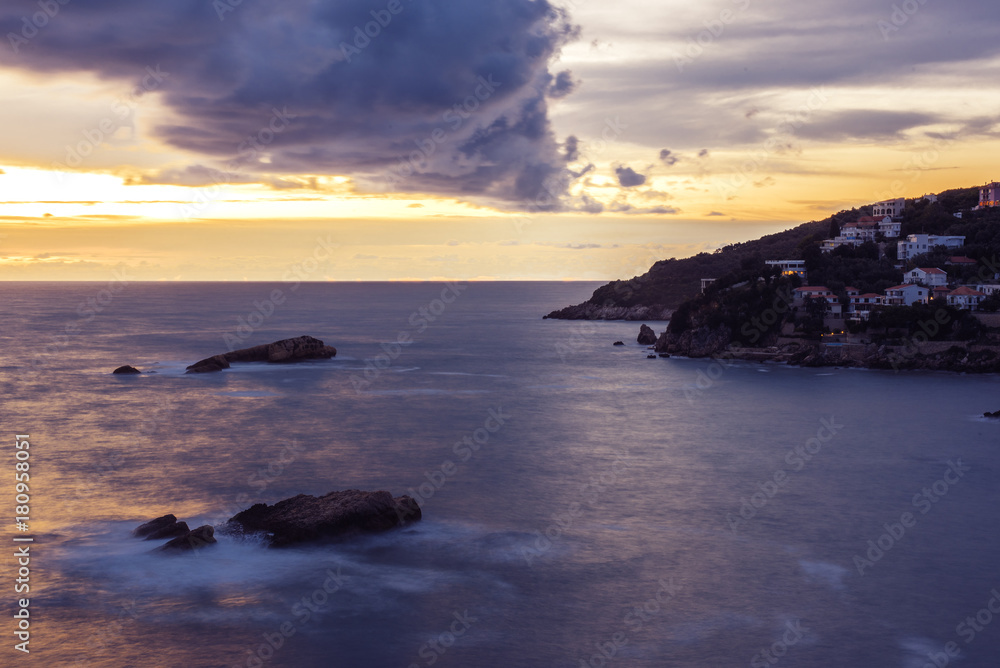 Fototapeta premium Montenegro, city of Ulcinj, the view of the sunset on the Adriatic sea in the storm with the old fortress, the month of October.